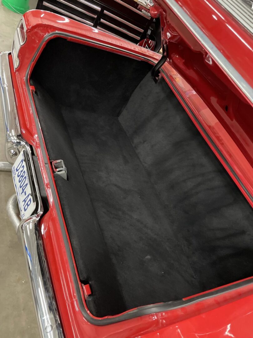 The trunk of a red vintage car at the shop