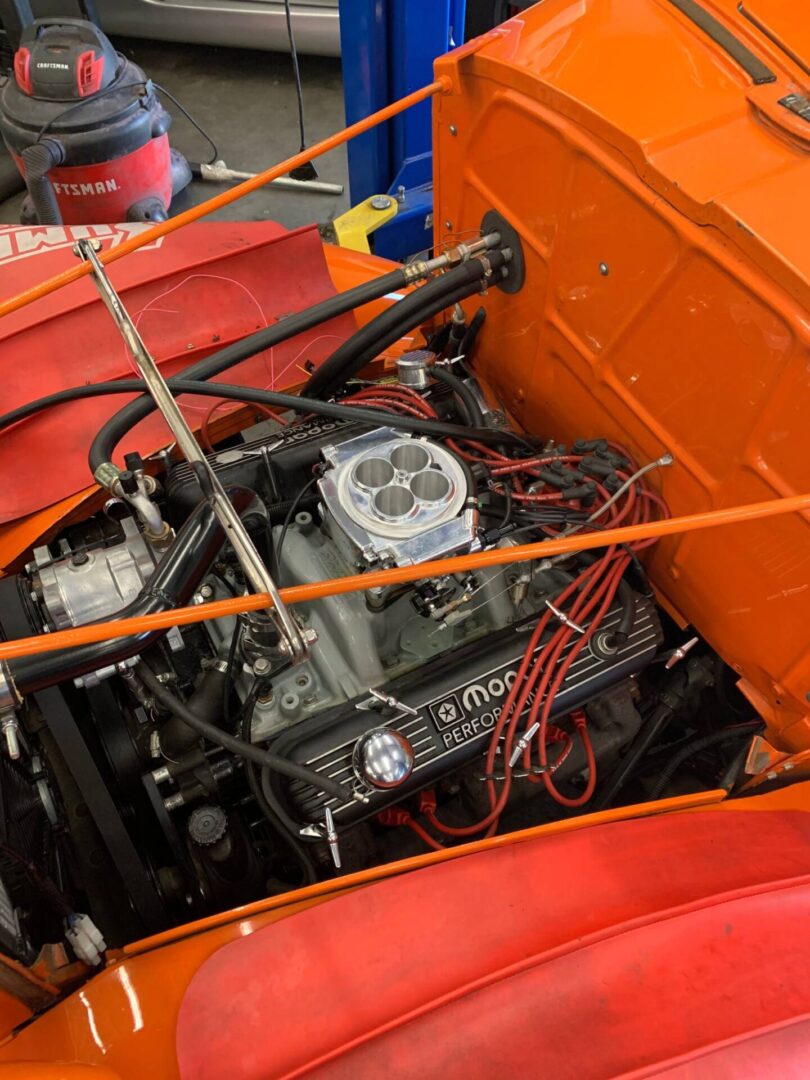 The inside view of a orange vintage car hood