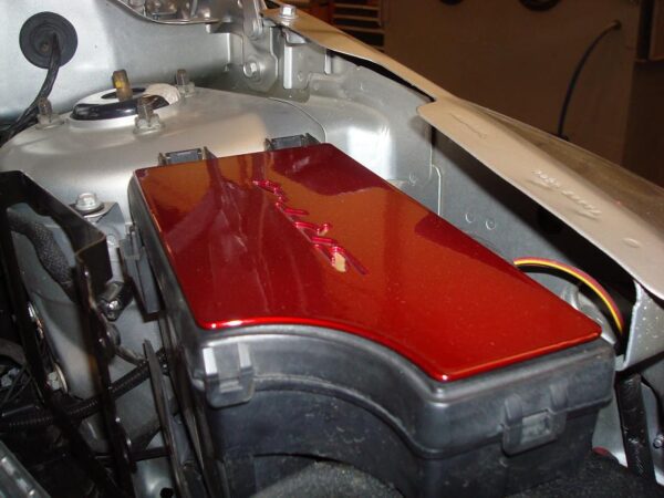 A red coated caliber fuse box cover