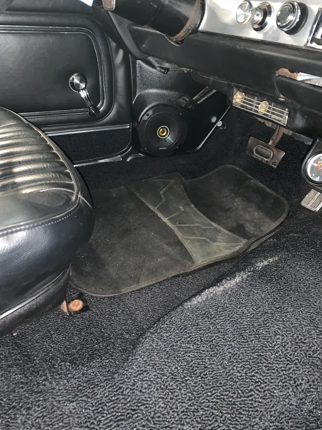 A black carpet cover for under the car seat