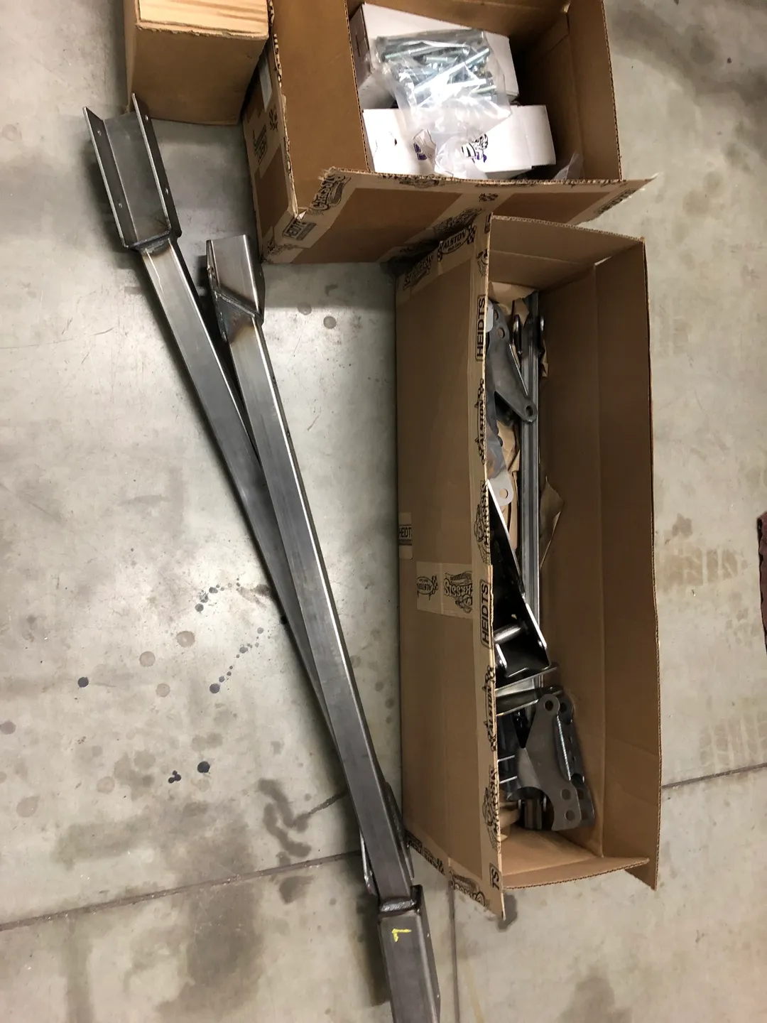 A bunch of long metal car parts inside a box