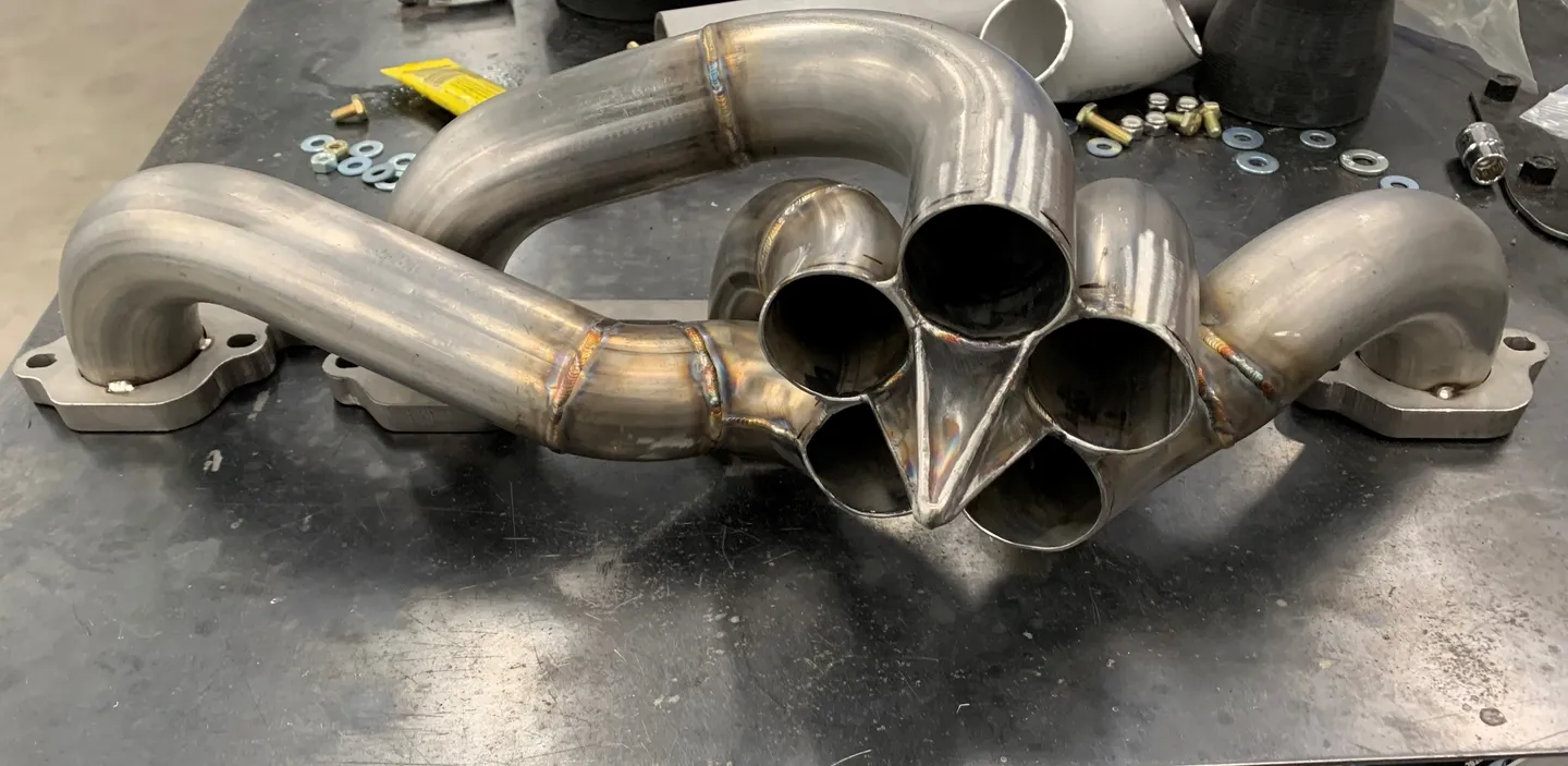 A metal car part with five pipes