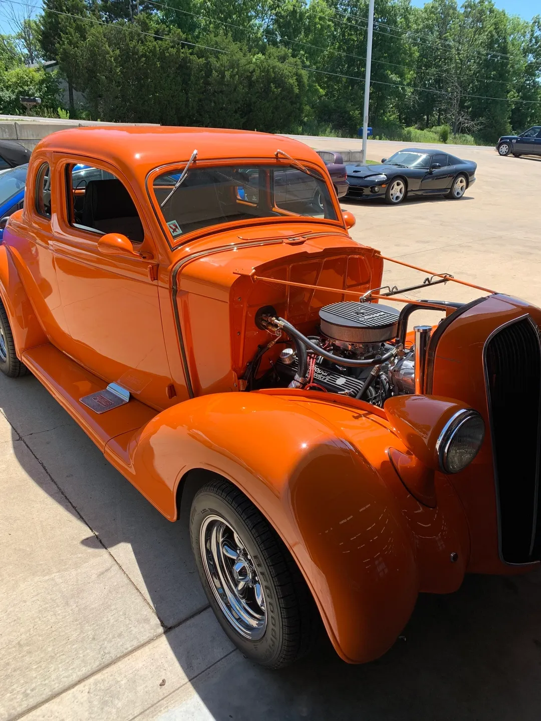 An orange vintage car parked outside