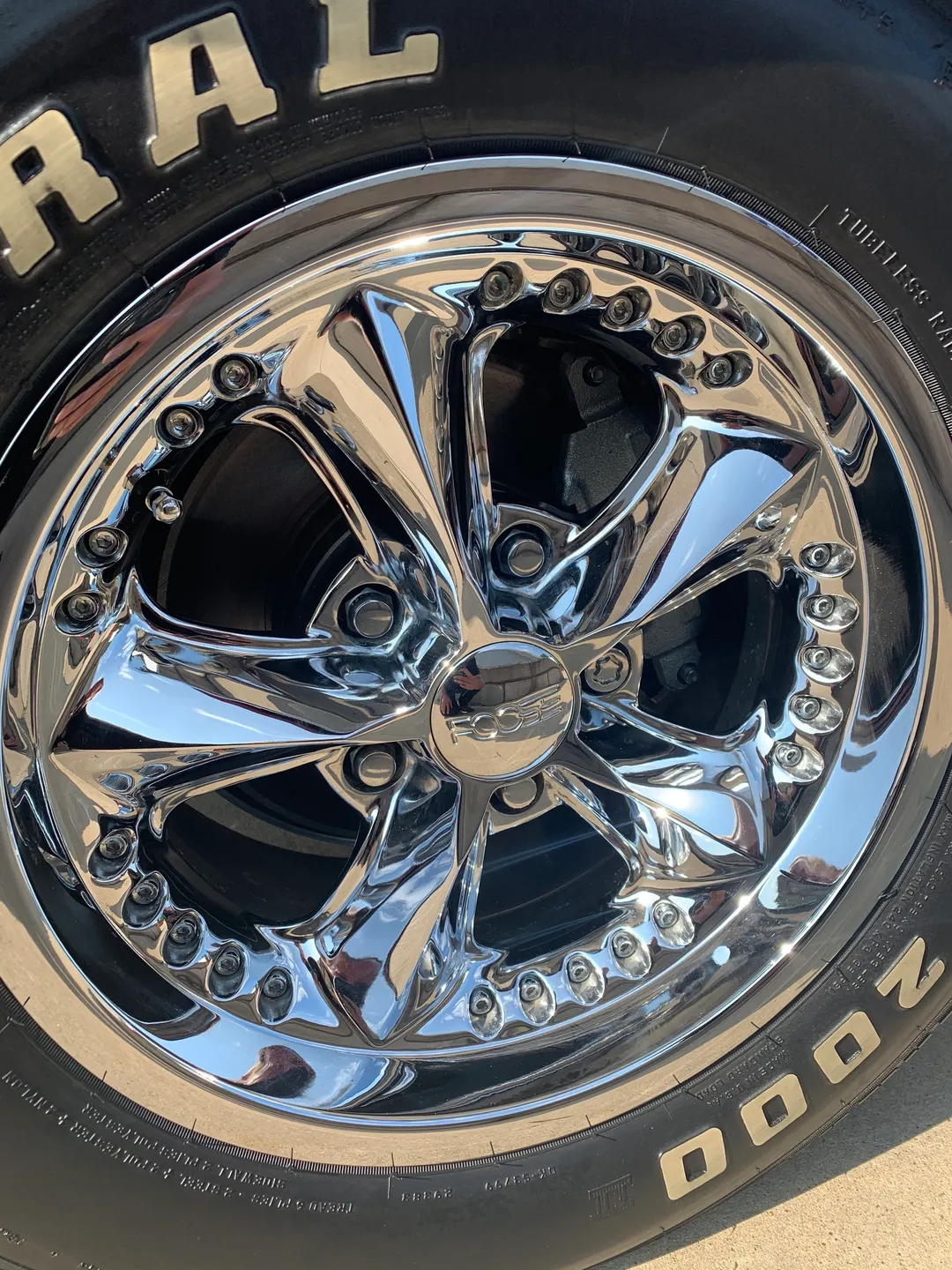 A glossy silver rim of a tyre of a car
