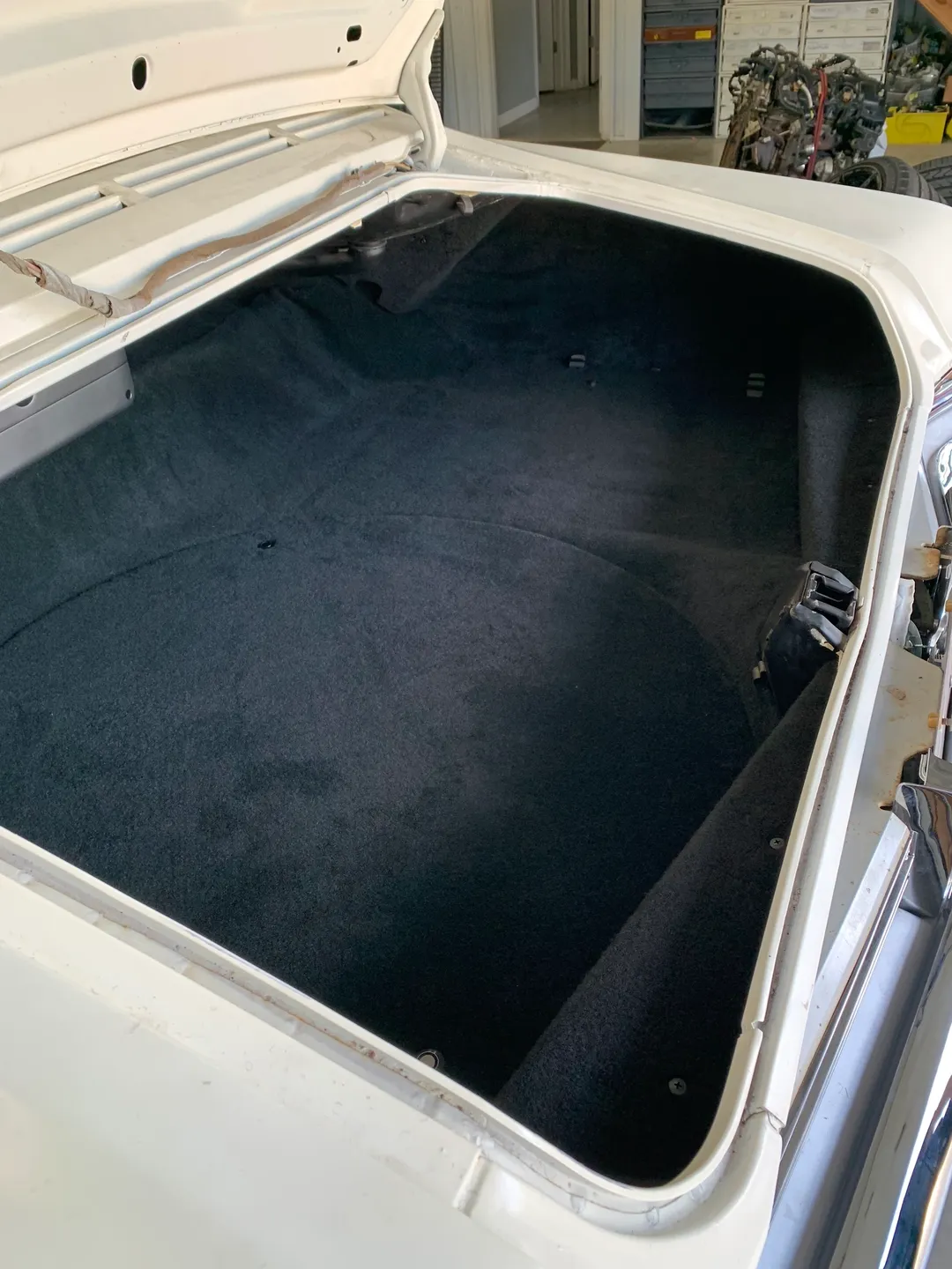 The open trunk of a white vintage car