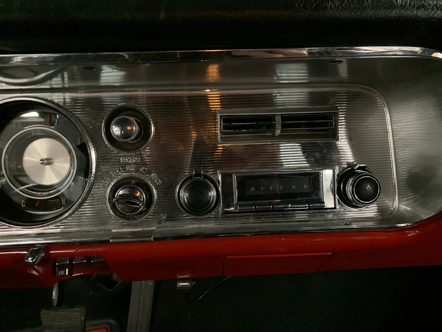 A silver stereo for a red vintage car