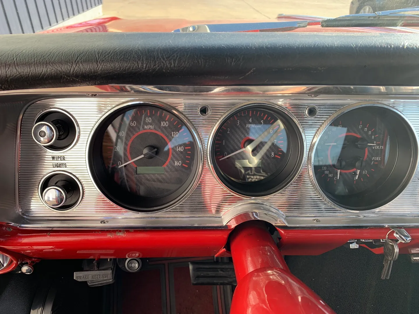 A speed clock for a red vintage car dashboard